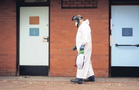  ??  ?? A worker for Leicester City Council disinfects public toilets, Leicester, June 29, 2020.