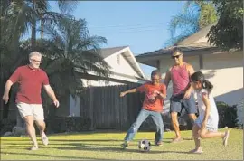  ?? Rick Loomis
Los Angeles Times ?? MATTHEW MANSELL, left, and John Espejo play soccer with their children Wyatt, 8, and Elyse, 7, right, in their yard. The couple wed in California in 2008.