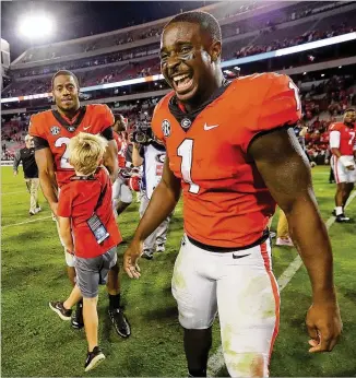  ?? CURTIS COMPTON / CCOMPTON@AJC.COM ?? Tailbacks Sony Michel (front) and Nick Chubb celebrate with a young Georgia fan after last weekend’s win over Kentucky capped the East Division champion’s SEC schedule.