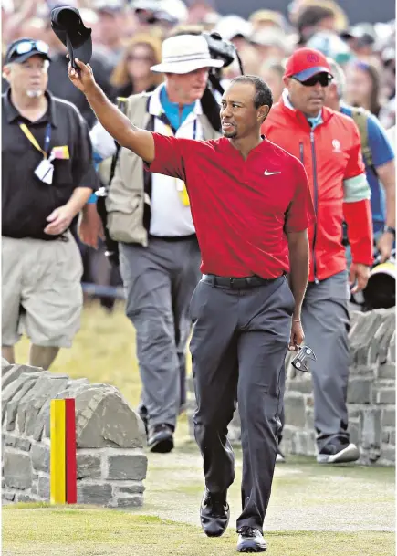  ??  ?? Back in the game: Tiger Woods salutes the crowds as he walks up the 18th at Carnoustie yesterday