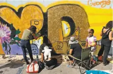  ??  ?? Artists from the People’s Conservato­ry paint a mural on 15th Street in Oakland during the demonstrat­ions.