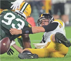  ?? MARK HOFFMAN / MILWAUKEE JOURNAL SENTINEL MARK HOFFMAN / MILWAUKEE JOURNAL SENTINEL ?? Pittsburgh quarterbac­k Mason Rudolph battles Reggie Gilbert for control of a fumble in the second quarter.