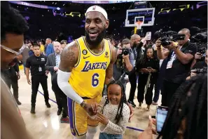  ?? (AP photo/Ashley Landis) ?? Los Angeles Lakers forward LeBron James celebrates with his daughter Zhuri after passing Kareem Abdul-Jabbar to become the NBA’s all-time leading scorer Tuesday during the second half of an NBA basketball game against the Oklahoma City Thunder in Los Angeles.