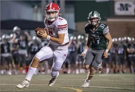  ?? AMANDA SAGBA / BOSTON HERALD ?? PROVING ELUSIVE: North Attleboro QB Chase Frisoli carries the ball as Mansfield’s Kyle Murphy chases on Friday night.