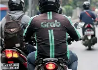  ?? — AP ?? A GrabBike driver rides on his motorbike in Jakarta, Indonesia, on Monday.