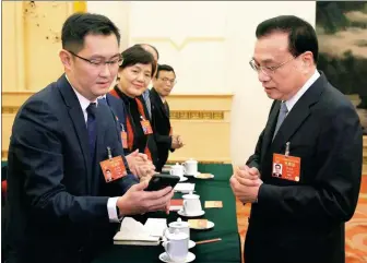  ?? WU ZHIYI / CHINA DAILY ?? Premier Li Keqiang learns about the latest developmen­t in online services from Pony Ma, chairman and CEO of Tencent and an NPC deputy, during a panel discussion on Thursday at the ongoing NPC session.