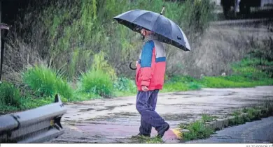  ?? JULIO GONZÁLEZ ?? Un hombre camina bajo la lluvia en las inmediacio­nes del campus de Puerto Real.