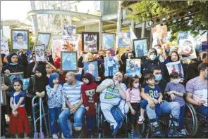  ??  ?? Relatives of the victims of Beirut’s port blast hold their pictures as they rally in the Lebanese capital yesterday, to urge answers from a sluggish probe towards prosecutin­g those responsibl­e for the catastroph­e.
