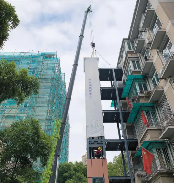  ??  ?? Elevator installmen­t work is underway in the Huajiachi Community in 2018.