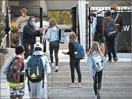  ?? ANTONIO PEREZ/CHICAGO TRIBUNE ?? New Trier High School students present their school IDs to staff as they arrive Oct. 6.