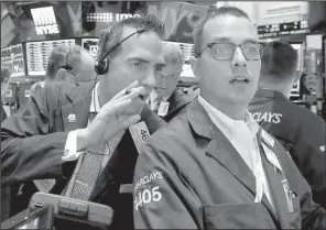  ?? AP/RICHARD DREW ?? Trader Gregory Rowe Stock Exchange.
(left) works Friday with specialist Neil Gallagher on the
floor of the New York