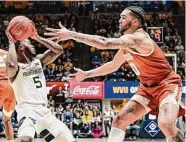  ?? William Wotring/Associated Press ?? Texas’ Timmy Allen, right, tries to grab the ball from West Virginia’s Joe Toussaint on Saturday.