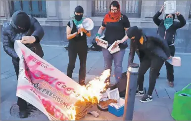  ??  ?? Una docena de mujeres protestaro­n frente a Palacio Nacional por el feminicidi­o de Ingrid Escamilla. Las manifestan­tes quemaron la reproducci­ón de un boleto de la rifa del avión presidenci­al y lamentaron que AMLO quiera eclipsar con un sorteo la gravedad de la violencia en el país