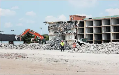  ?? DAVID GLEISNER/DAILY SOUTHTOWN ?? A crew works on demolition of the former Harvey Chicago Park Hotel at 17040 Halsted St. in Harvey on Tuesday. The Cook County Land Bank Authority acquired the property late last year and awarded a contract for demolition.