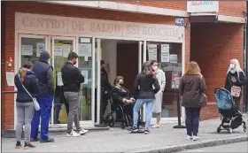  ?? (AP/Paul White) ?? People line up Tuesday outside a local health center in Madrid, Spain.