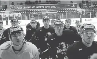  ?? UNO YI ?? The Anyang Halla hockey team takes a break during practice to listen to their coach at the Anyang Ice Arena in Seoul, South Korea.