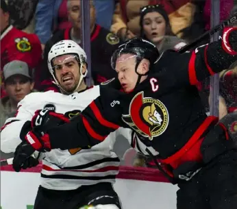  ?? ASean Kilpatrick/Canadian Press ?? Chicago’s Jaycob Megna, left, and Ottawa’s Brady Tkachuk slam into the boards in the second period Thursday night in Ottawa.