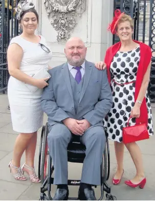  ??  ?? Carl Eaton, founder of the Skem MenAces, with wife Miriam and daughter Samantha at Buckingham Palace