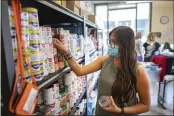  ?? JASON HALLEY — CHICO STATE ?? Chico State student Michelle Tapia selects cans of beans from the shelf at the Hungry Wildcat Food Pantry at Chico State in Chico.