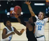  ?? JOHN LOCHER – THE ASSOCIATED PRESS ?? Oregon State’s Warith Alatishe puts up a shot between UCLA’s David Singleton, left, and Mac Etienne.