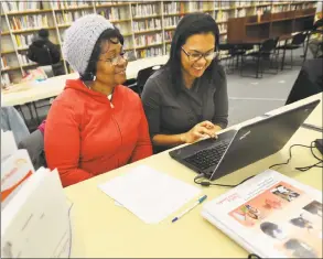  ?? Brian A. Pounds / Hearst Connecticu­t Media file ?? Dionne Williams, left, of Bridgeport, signs up for health insurance with Access Health CT enrollment specialist Rosalina De Los Santos at the Bridgeport Public Library in 2014.