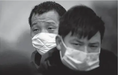  ?? REUTERS/THOMAS PETER ?? People coming from the Hubei province wait at a checkpoint at the Jiujiang Yangtze River Bridge in Jiujiang, Jiangxi province, China, as the country was hit by an outbreak of a new coronaviru­s on Feb. 1.