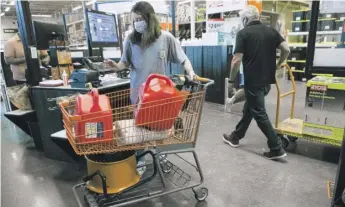  ?? BRETT COOMER/HOUSTON CHRONICLE VIA AP ?? Gigi Hlavink buys gas cans and other supplies Tuesday at a Home Depot store in Houston while preparing for the possible landfall of Hurricane Laura in Houston.