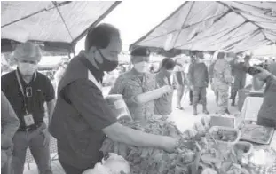  ?? AFP PUBLIC AFFAIRS OFFICE/PHILIPPINE NEWS AGENCY ?? AGRICULTUR­E Secretary William D. Dar (second from left) and Armed Forces of the Philippine­s Deputy Chief of Staff Lt. Gen. Antonio Ramon Lim (wearing black beret) inspect vegetables and other agricultur­al products sold at the Kadiwa retail store in Camp Aguinaldo, Quezon City, on Saturday, July 11.