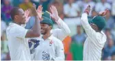  ??  ?? Zimbabwe’s Tendai Chatara (left) celebrates with team-mate Regis Chakabva (centre) after a dismissal during the second day of the first Test against Bangladesh. — AFP