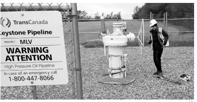  ?? AP ?? In this October 11, 2016 photo provided by Samuel Jessup, climate change activist Michael Foster, of Seattle, turns an emergency shut-off valve on an oil pipeline in northeaste­rn North Dakota. Foster was arrested and ended up spending six months in jail. The valve-turning tactic has been embraced in recent years by activists who believe fossil fuels are precipitat­ing a global warming crisis. But the energy industry and its advocates say it amounts to domestic terrorism, and lawmakers in several states are considerin­g stiffening penalties.