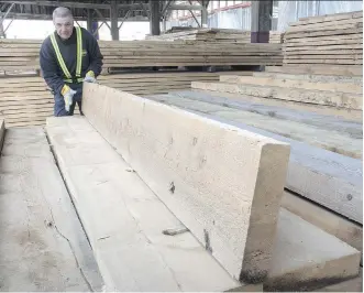  ?? PAUL CHIASSON/THE CANADIAN PRESS FILES ?? A worker tidies up the wood pile at a lumber yard in Montreal. David MacNaughto­n, Canada’s ambassador to the U.S., says Canada is open to any resolution that could resolve the softwood lumber dispute as the U.S. industry uses its veto power to block...