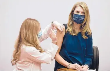  ?? JESSICA HILL/AP ?? Pharmacist Madeline Acquilano, left, gives kindergart­en teacher Christina Kibby the Johnson & Johnson COVID-19 vaccine Wednesday at Hartford Hospital in Connecticu­t. Many districts haven’t been tallying school employee vaccines.