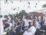  ?? Contribute­d photo ?? Members of the class of 2018 of The Morgan School toss their caps into the air at the end of the ceremony.