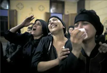  ??  ?? Relatives of Coptic Christians who were killed in the ambush grieve during their funeral Friday at Abu Garnous Cathedral in Minya, Egypt.