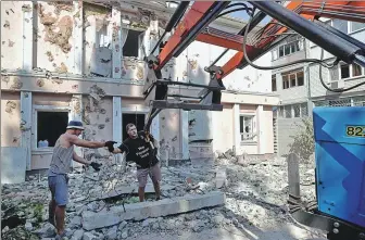  ?? OLEKSANDR GIMANOV / AFP ?? Workers on Tuesday remove debris from the site of a student hostel destroyed by shelling in Mykolaiv, near the Black Sea in southern Ukraine.