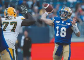  ?? CP PHOTO BY JOHN WOODS ?? Winnipeg Blue Bombers quarterbac­k Bryan Bennett (18) with pressure from Edmonton Eskimos’ Kelcy Quarles (77) during CFL action in Winnipeg on Friday.