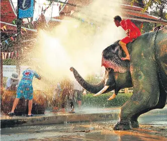  ?? ?? Un elefante arroja agua con su trompa a los viandantes en la fiesta del Songkran, el Año Nuevo de Tailandia.