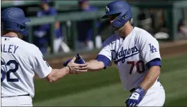  ?? ROSS D. FRANKLIN — THE ASSOCIATED PRESS ?? Los Angeles Dodgers’ DJ Peters (70) celebrates his two-run home run against the Colorado Rockies with teammate Luke Raley, left, during the second inning of a spring training baseball game Monday in Phoenix.