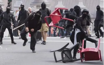  ?? JACQUES BOISSINOT/THE CANADIAN PRESS ?? Demonstrat­ors hurls a chair during an anti-racism protest in Quebec City on Sunday.