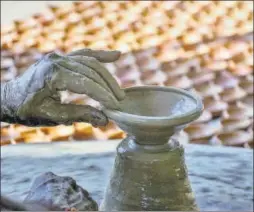  ?? PTI ?? A potter makes traditiona­l earthen lamps ahead of Diwali , in Guwahati on Thursday.