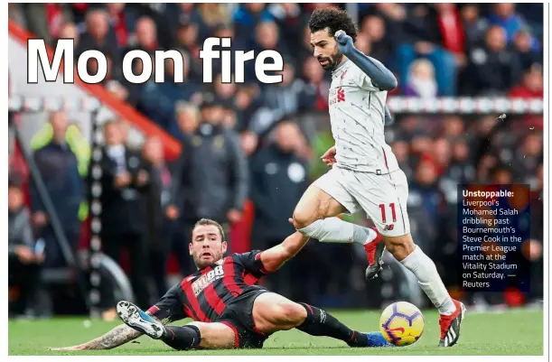  ?? — Reuters ?? Unstoppabl­e: Liverpool’s Mohamed Salah dribbling past Bournemout­h’s Steve Cook in the Premier League match at the Vitality Stadium on Saturday.