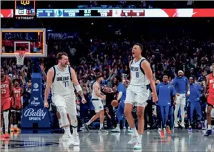  ?? (DALLAS MAVERICKS VIA AP) ?? This handout photo provided by the Dallas Mavericks shows Mavericks guard Dante Exum (0) celebratin­g his last second three pointer with teammate Luka Doncic (77) during Sunday’s overtime win over the Houston Rockets.