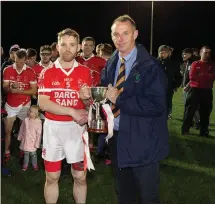  ??  ?? Tinahely captain Ray McGlynn accepts the cup from county chairman Martin Fitzgerald.