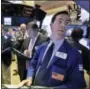  ?? RICHARD DREW — THE ASSOCIATED PRESS ?? Specialist John McNierney, right, works with traders at his post on the floor of the New York Stock Exchange on Friday.