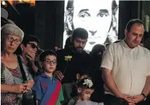  ?? KAREN MINASYAN/AFP/GETTY IMAGES ?? People lay flowers and say prayers in memory of French-Armenian singer Charles Aznavour at the square named after him in Yerevan, the Armenian capital, on Monday.