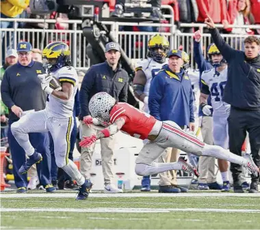  ?? Ben Jackson/Getty Images ?? Michigan running back Donovan Edwards eludes a tackle attempt by Lathan Ransom during the fourth quarter. Edwards scored on TD runs of 75 and 85 yards in the fourth and finished with 216 rushing yards.