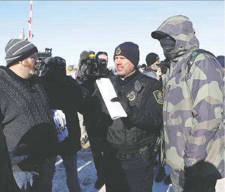  ?? CODIE MCLACHLAN/REUTERS ?? The CN Police arrive to serve an injunction Wednesday as supporters of the Indigenous Wet’suwet’en Nation’s hereditary chiefs camp at a railway blockade in Edmonton. The group joined protests across the country against British Columbia’s Coastal Gaslink pipeline.