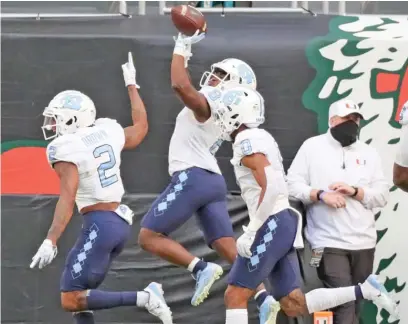  ?? AL DIAZ/ AP ?? North Carolina running back Michael Carter ( 8), who ran for 308 yards Saturday, celebrates one of his two touchdowns.