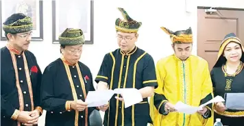  ??  ?? Tangau (centre) going through the details of the state level Internatio­nal Day of the World’s Indigenous Peoples celebratio­n with Angang (second left).