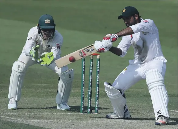  ?? AP ?? Pakistan’s Sarfraz Ahmed plays a shot as Australia wicketkeep­er-captain Tim Paine looks on during the second Test in Abu Dhabi, which Pakistan won